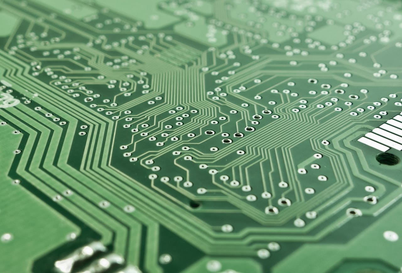 Electronic components and signal pathways on a green circuit board.